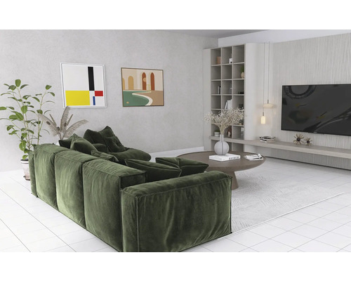 Wohnzimmer mit grüner Couch, rundem Tisch und Bücherregal