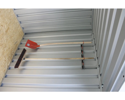 Innenansicht eines Gerätehauses mit Gerätehalterung, an der eine Schaufel und ein Besen befestigt sind