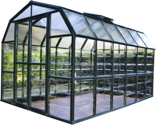 Gewächshaus mit Regalen und transparenter Verglasung.
