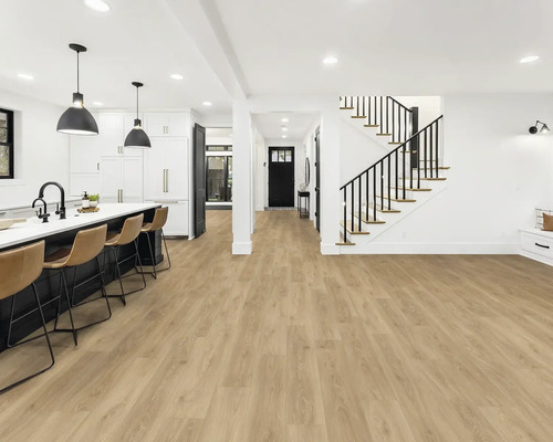 Heller Raum mit offener Küche, Treppe und Vinylboden in Holzoptik.