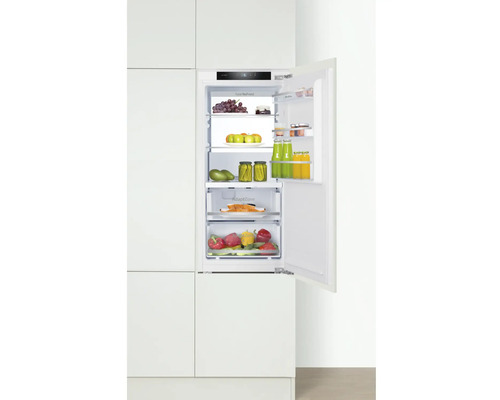 Integrierter Kühlschrank mit geöffneter Tür, gefüllt mit Lebensmitteln in einem Küchenschrank.