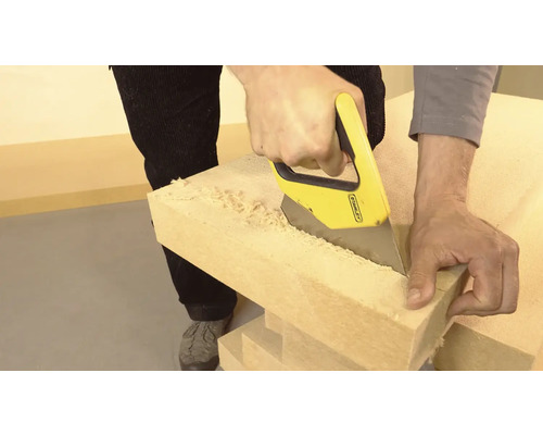 Mann sägt Holz mit einer Handsäge.