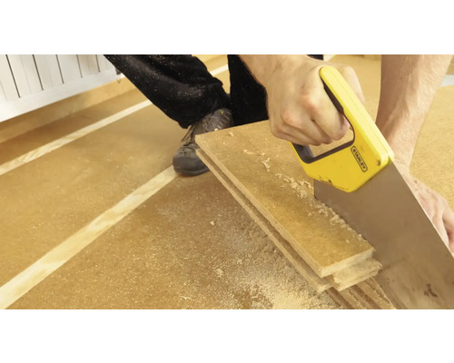 Eine Person sägt Holz mit einer Handsäge von Stanley.