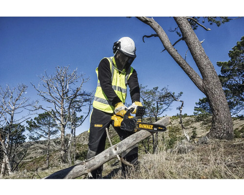 Eine Person mit Schutzausrüstung schneidet mit einer DeWalt Kettensäge einen Baumstamm.