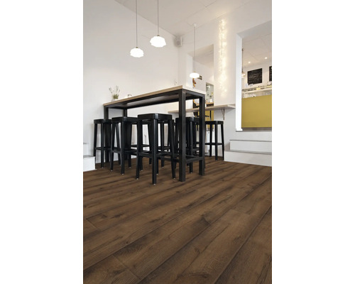 Innenraum mit dunklem Laminatboden, einem Hochtisch und schwarzen Barhockern.