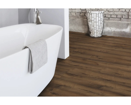 Badezimmer mit freistehender Badewanne, Wäschekorb und Laminatboden in Holzoptik.