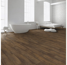 Heller Raum mit Badewanne, Bett und Boden aus Holzoptik