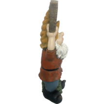 Gartenzwerg Figur beim Klettern an einem Baumstamm