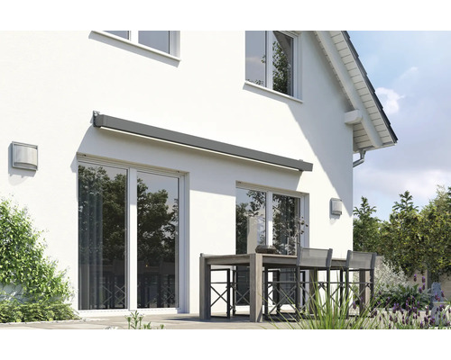 Hausfassade mit montierter Gelenkarmmarkise und Sitzgruppe