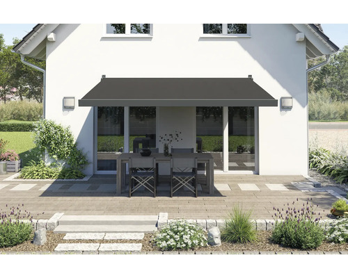 Terrasse mit Markise, Tisch und Stühlen vor einem Haus.