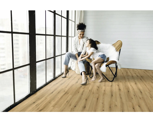 Helles Wohnzimmer mit Holzboden und Mutter mit Kind am Fenster