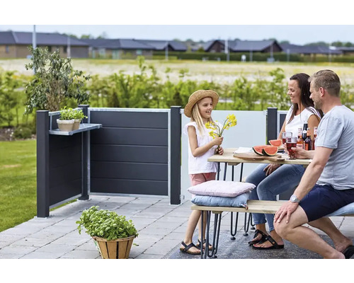 Familie genießt die Zeit im Garten mit einem Sichtschutzzaun mit Ablagefläche.