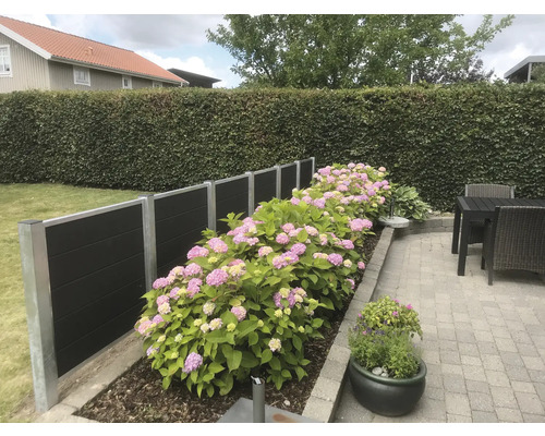 Garten mit Sichtschutzzaun, Hortensien und Pflastersteinen