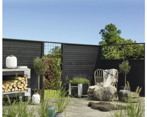 Dekorativer Gartenbereich mit Holzzaun, Stuhl und Pflanzen