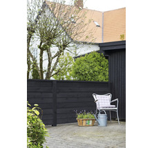Gartenszene mit Holzzaun, Gartenstuhl, Gießkanne und Pflanzenkorb