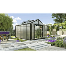 Gewächshaus mit geöffneten Türen in einem Garten mit Pflanzen und Gartenmöbeln.