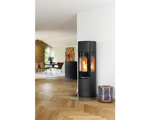 Wohnzimmer mit Kaminofen, Brennholzkorb und Esstisch