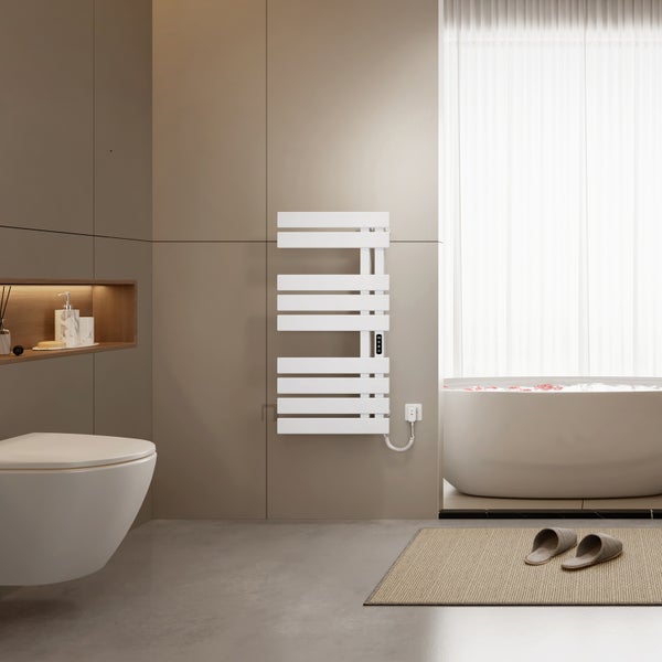 Modernes Badezimmer mit weißem elektrischem Handtuchheizkörper an einer Fliesenwand, freistehender Badewanne und wandhängendem WC.