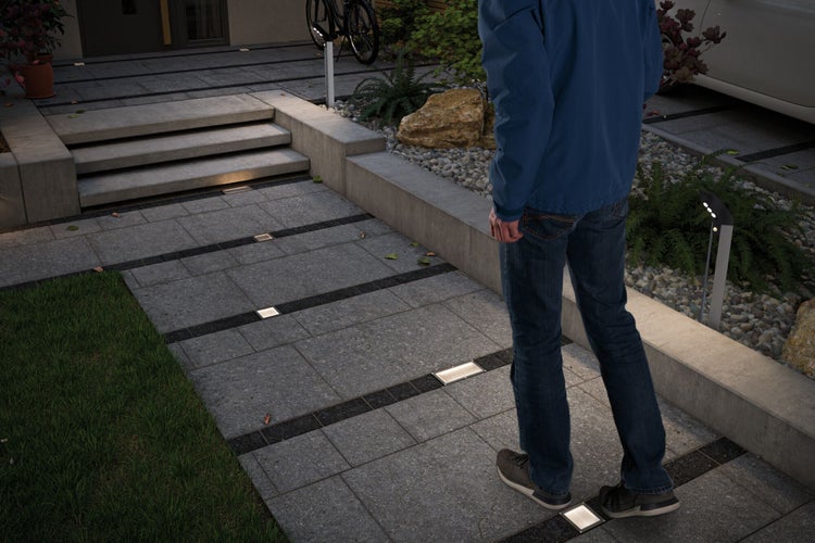 Außenbereich mit Pflastersteinen und eingelassenen Leuchten für den Gartenweg