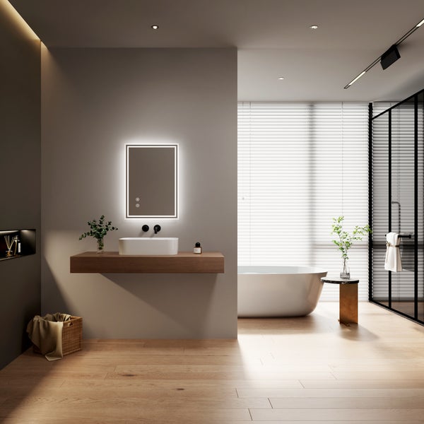 Modernes Badezimmer mit freistehender Badewanne, Aufsatzwaschbecken auf Holzkonsole und beleuchtetem Wandspiegel in einem hellen, offenen Raum.