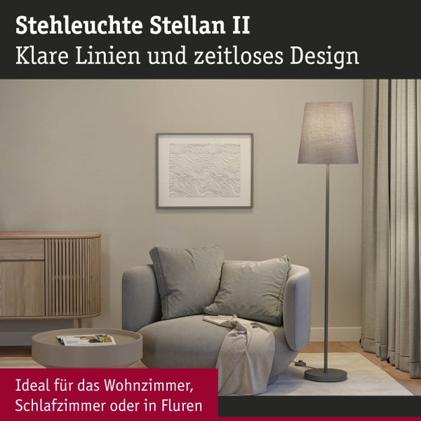 Stehlampe in einem Wohnzimmer mit Sessel, Tisch und Kommode