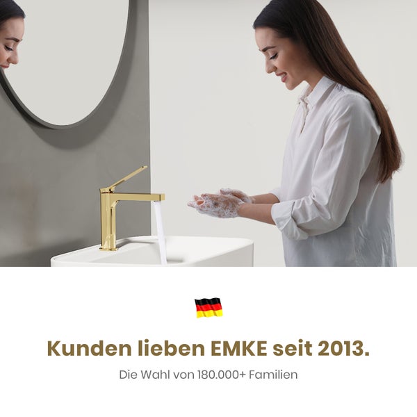 Frau wäscht sich die Hände an einem goldenen Wasserhahn in einem Badezimmerwaschbecken