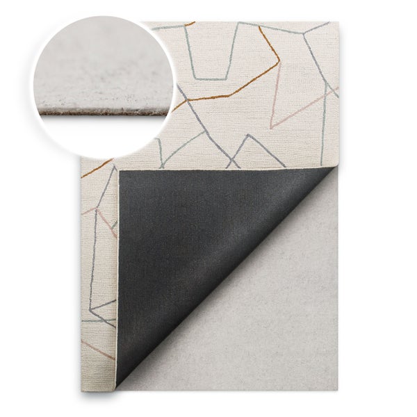 Teppich mit geometrischem Linienmuster, umgeknickte Ecke zeigt die dunkle Rückseite und Unterlage, Detailansicht der Materialstärke.