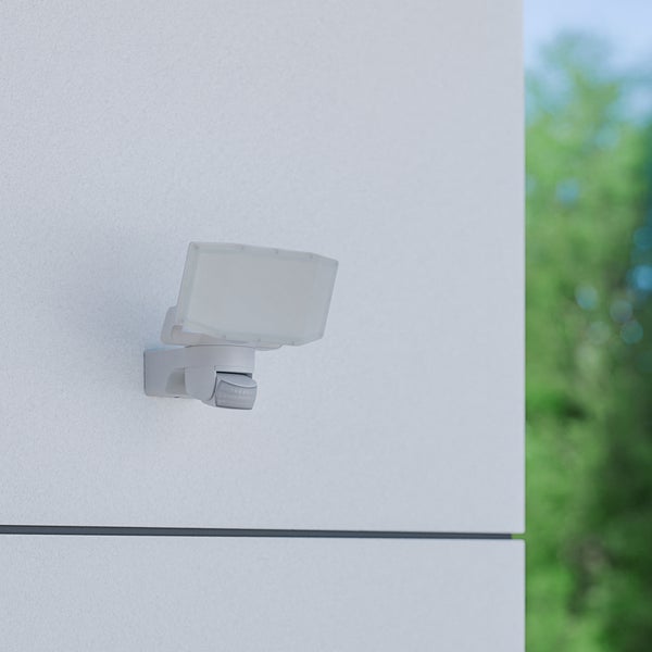 LED-Außenstrahler mit integriertem Bewegungsmelder, montiert an einer Außenwand.