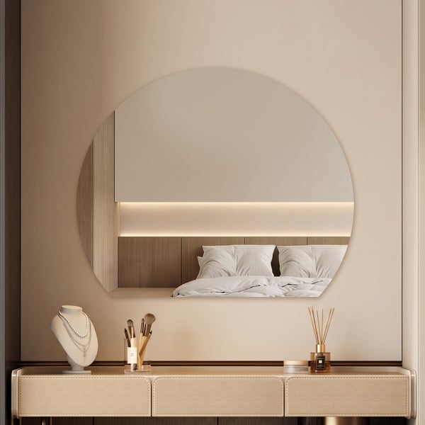 Runder Wandspiegel über einer eleganten Konsole in einem modernen Schlafzimmer.