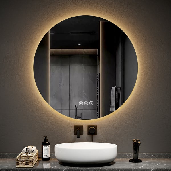 Badezimmer mit rundem Spiegel, Waschbecken und Armaturen auf einer Arbeitsplatte