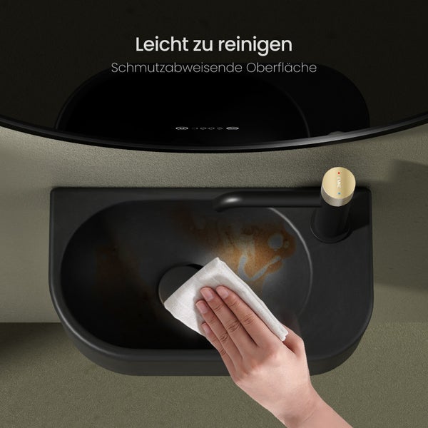 Ein schwarzes Waschbecken wird mit einem Tuch gereinigt, was die einfache Reinigung demonstriert.