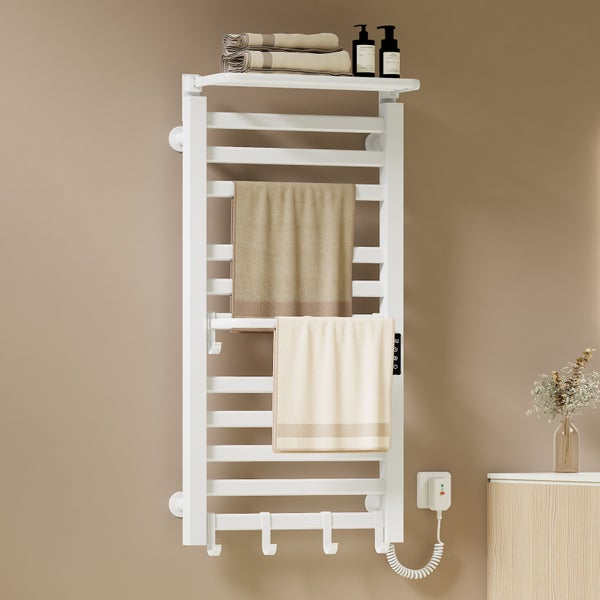 Weißer Handtuchwärmer mit Handtüchern, Ablage und Kosmetikprodukten im Badezimmer.