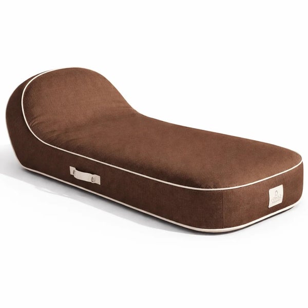 Ergonomisches braunes Hundebett mit erhöhter Kopfstütze, weißer Paspelierung und praktischem seitlichem Tragegriff.