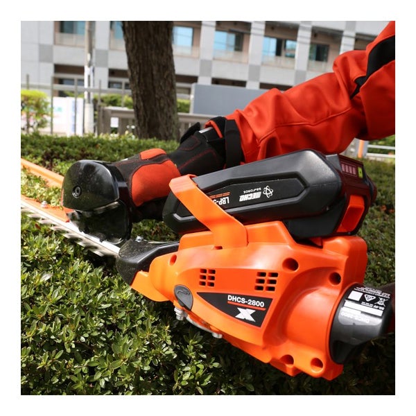 Bedienung einer Akku-Heckenschere beim Schneiden einer Hecke.