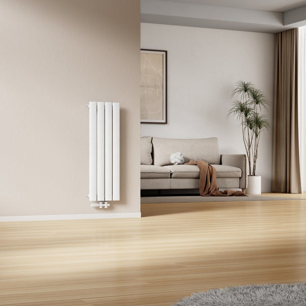 Moderner vertikaler Flachheizkörper an einer Wand in einem stilvoll eingerichteten Wohnzimmer mit Sofa und Holzboden.
