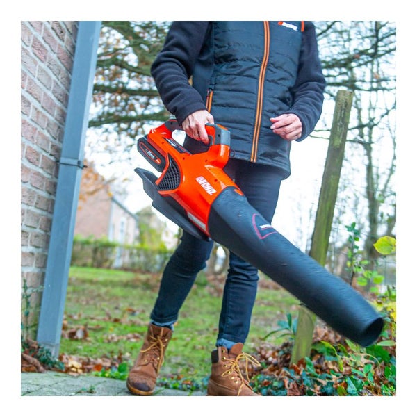 Person verwendet einen Laubsauger im Garten