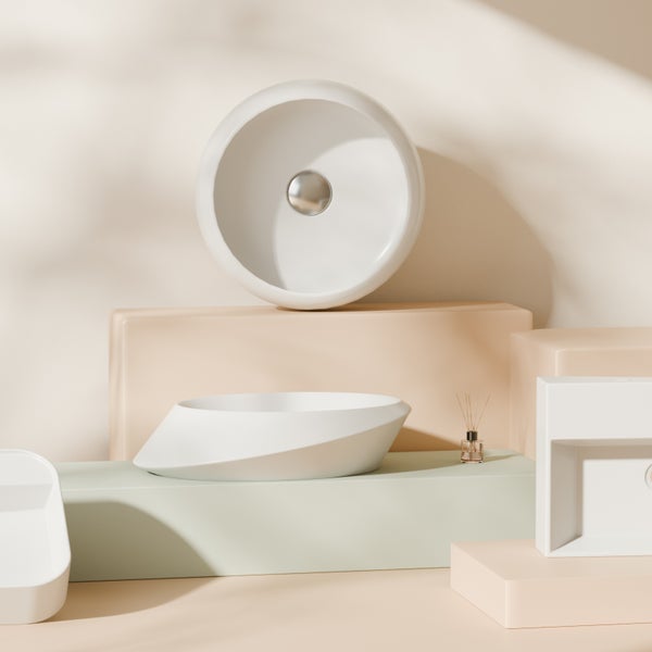 Verschiedene weiße Aufsatzwaschbecken auf unterschiedlich hohen Sockeln für ein modernes Badezimmerdesign.