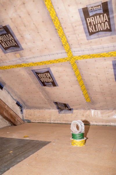 Variable Dampfbremse Prima Klima im Dachausbau, mit Klebeband abgedichtet. Rollen Klebeband im Vordergrund.