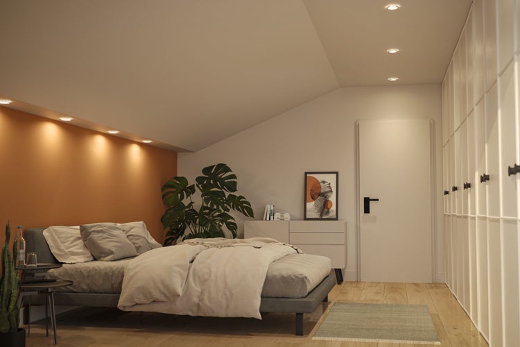 Schlafzimmer mit Doppelbett, Kommode und Einbauschrank unter einer Dachschräge.
