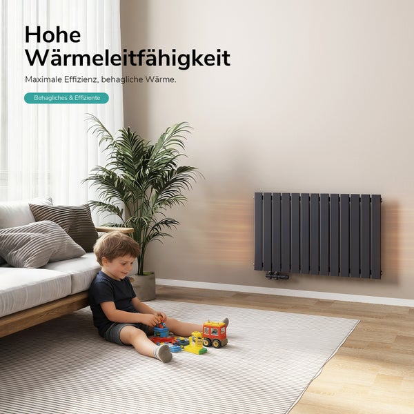 Wohnraum mit Heizkörper, Couch, Pflanze und spielendem Kind auf einem Teppich
