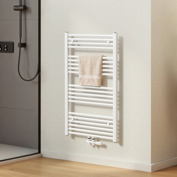 Weißer Handtuchwärmer mit Handtuch im Badezimmer