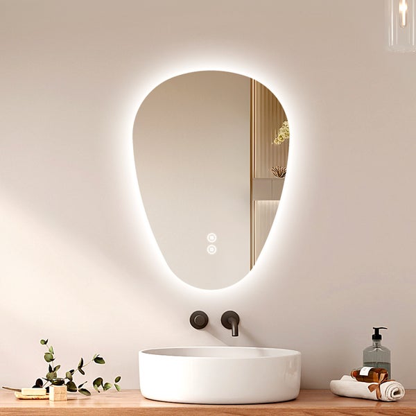 Organisch geformter Badezimmerspiegel mit LED Beleuchtung und Touch Funktion über einem runden Aufsatzwaschbecken auf einem Holzwaschtisch.