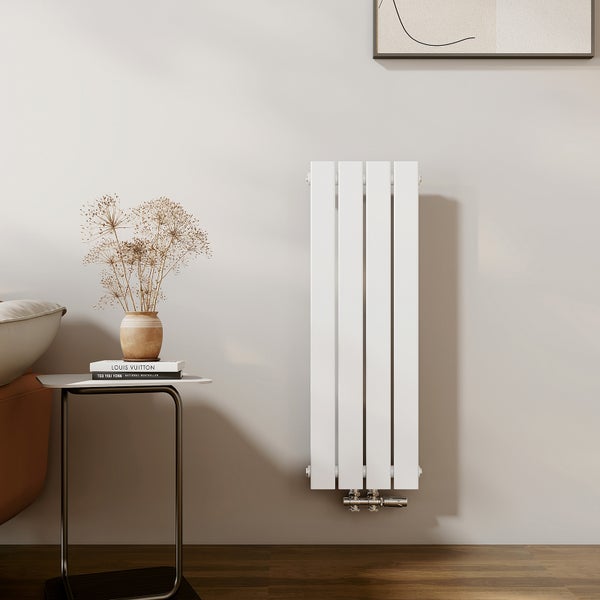 Weißer Heizkörper an der Wand, neben einem Tisch mit Dekoration