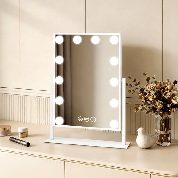 Beleuchteter Kosmetikspiegel mit Vase und Dekoration auf einem Tisch