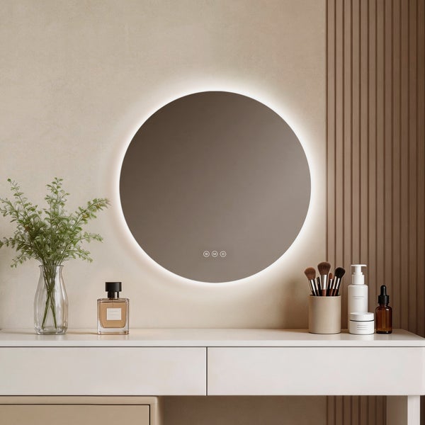 Moderner, runder Badspiegel mit LED-Hintergrundbeleuchtung und Touch-Sensoren über einem weißen Schminktisch in hellem, organisiertem Ambiente.