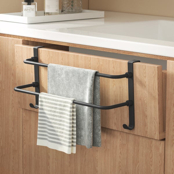Schwarzer Handtuchhalter mit zwei Handtüchern an einer Schranktür befestigt