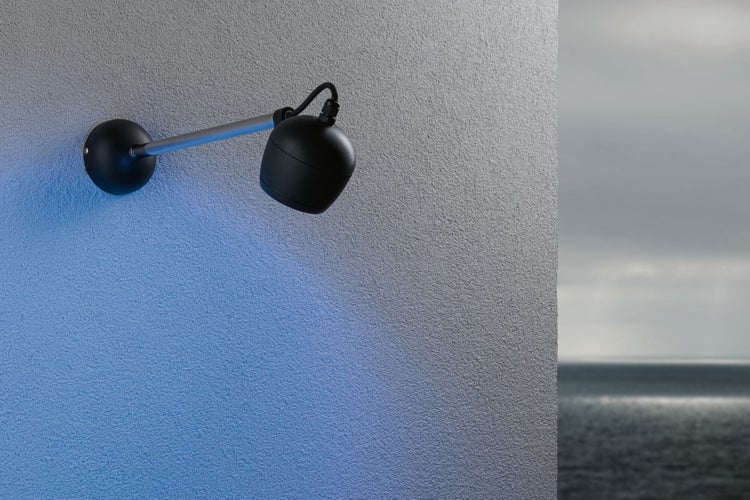 Wandleuchte mit verstellbarem Spot an grauer Wand