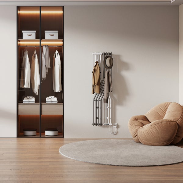 Moderner Designheizkörper als Handtuchhalter an einer Wand neben einem begehbaren Kleiderschrank mit indirekter Beleuchtung und Sitzsack im Raum.