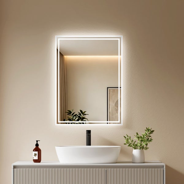 Rechteckiger LED Wandspiegel mit indirekter Beleuchtung über einem Waschbecken in einem modernen Badezimmer.