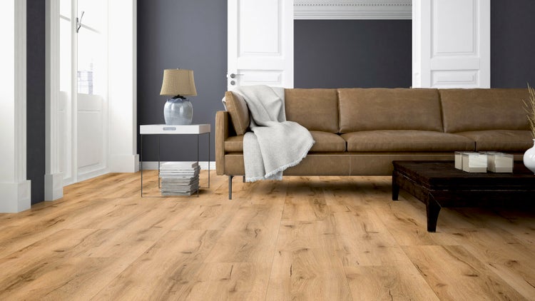 Laminatboden in Eichenholzoptik in einem modernen Wohnzimmer mit braunem Ledersofa und Couchtisch.